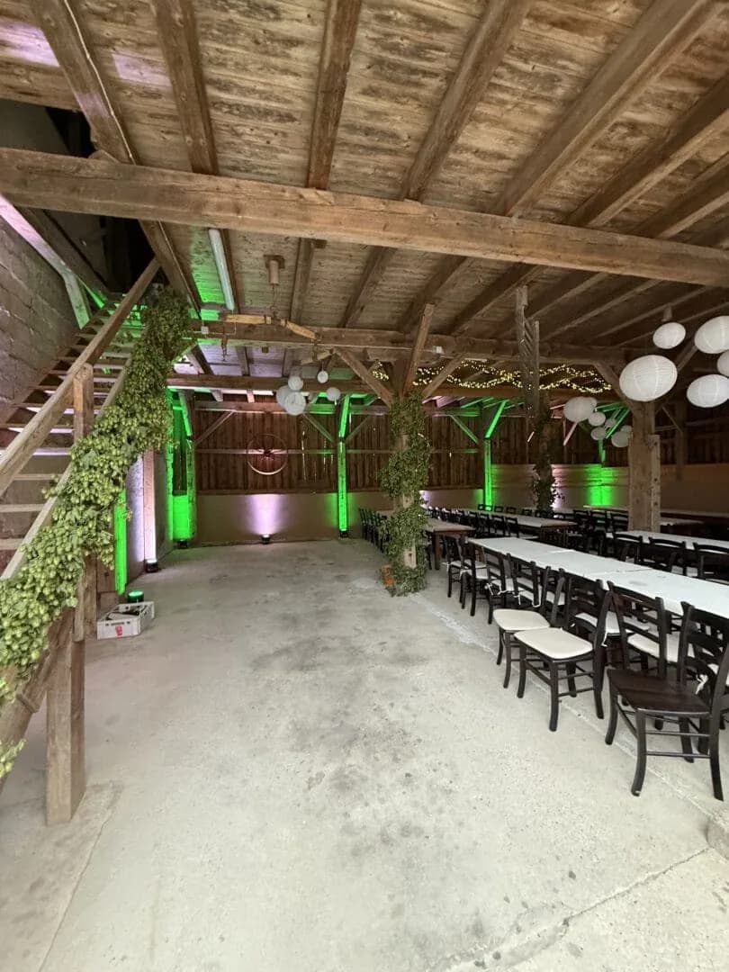 Grün und warmweiß beleuchtete Hochzeitslocation mit Lichttechnik von Event4U